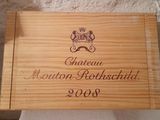 the wooden box is holding a bottle of wine and a plaque
