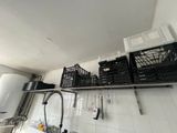 many baskets on the shelf above the sink in the kitchen