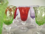 several different colored glass vases are lined up on a table