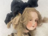 a doll that is laying down on a white blanket