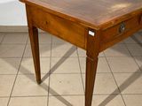 a small table with a drawer on it on a tiled floor