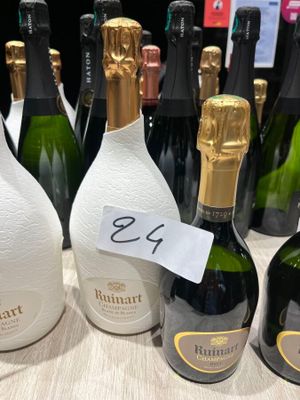 Des bouteilles de vin sont alignées sur une table, accompagnées d'une étiquette de prix