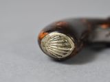 a close up of a pen with a shell on it