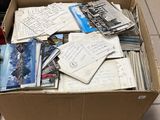 une boîte en carton remplie de vieilles cartes postales et d'autres objets