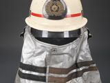 fireman ' s helmet and protective jacket on a black background