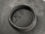 a close up of a black vase with writing on it