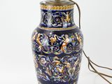 a blue and gold vase with a light on it