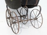 an old fashioned baby carriage that is sitting on the ground