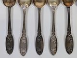 five spoons that are lined up on a table