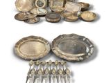 beaucoup d'assiettes et de cuillères en argent sur la table