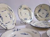 several blue and white plates are arranged on a white surface