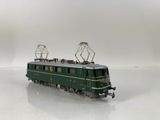 a green train on the tracks on a white surface
