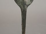 sculpture of a spoon on a black stand with a white background
