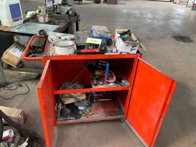 a red cabinet with tools on it in a garage
