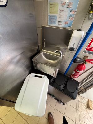 a toilet and a trash can in a public restroom
