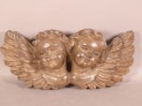 deux statues d'anges assis sur une surface blanche