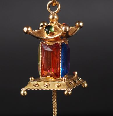 une image représentant un collier en or surmonté d'une couronne