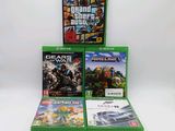 Trois jeux Xbox sont empilés les uns sur les autres sur une surface blanche