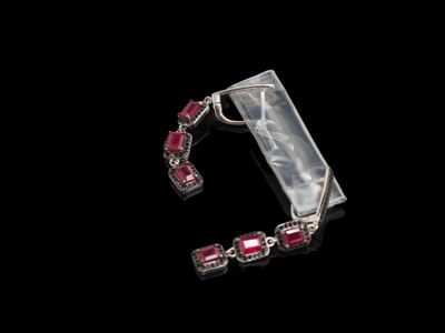 gros plan d'une paire de boucles d'oreilles sur une surface noire