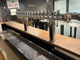 un long comptoir avec toute une série de robinets à bière