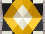 an image of a black and white and yellow geometric painting on a brick wall