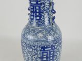 a blue and white vase sitting on a wooden stand