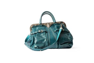 sac à main de couleur turquoise posé sur une surface blanche, sur fond blanc