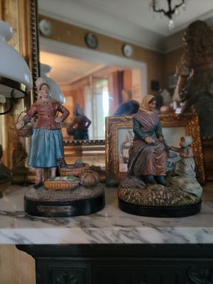 two figurines of people sitting on a table