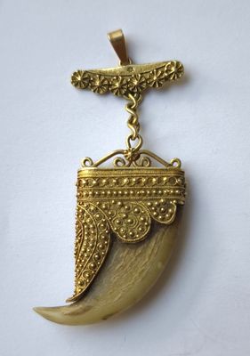 un gros plan d'un pendentif en or surmonté d'un oiseau
