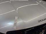 a close up of a white car with a sticker on it ' s hood