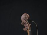 an old violin is sitting on top of a wooden stand