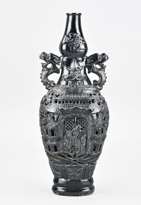 un vase noir orné d'un dragon sur fond blanc