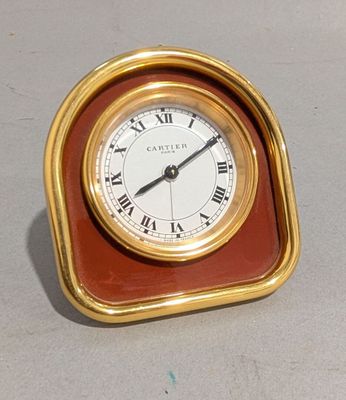 une petite horloge avec des chiffres romains