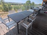 une table et des chaises sur un balcon donnant sur un champ
