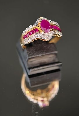gros plan d'une bague en or avec un rubis et des diamants