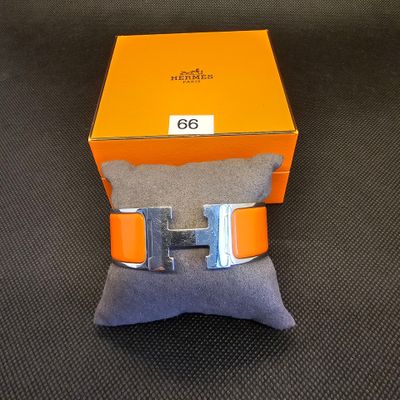 une boîte orange surmontée d'une boucle argentée, posée sur un oreiller