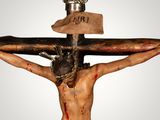 a statue of jesus on the cross with a crown on his head