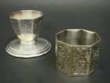 une tasse et une soucoupe en argent posées l'une à côté de l'autre sur une table