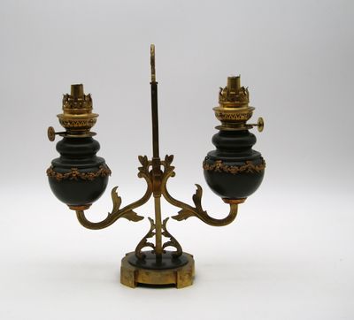 une image représentant une paire de bougeoirs noirs et dorés posés sur un socle