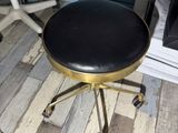 a black and gold stool with a black seat on it