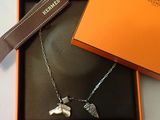 une boîte orange contenant un collier orné d'un chien en argent