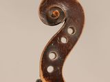 a close up of the back of a violin with a fiddle in the foreground