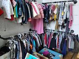 a lot of clothes hanging on a rack in a room
