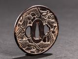 a close up of a metal plate with a dragon on it