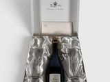 une bouteille de champagne dans un coffret cadeau, posée sur une surface blanche