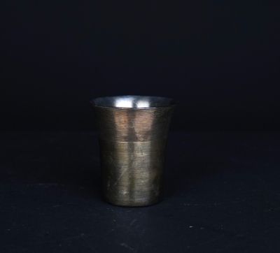 Gros plan sur une tasse en métal posée sur une surface noire