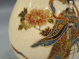 a white vase with a gold and blue design on it