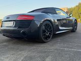 the rear end of a black audi sports car parked in a parking lot