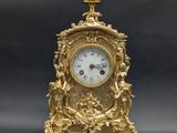 a gold clock sitting on top of a black table