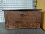 an old wooden chest with a drawer on top of it